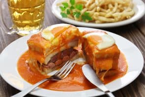 Francesinha: Dies ist ein herzhaftes Sandwich aus Porto, das jedoch auch in Lissabon erhältlich ist. Es enthält gewöhnlich Rindfleisch, Wurst und Schinken, überzogen mit einer würzigen Tomatensauce und Käse.