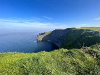 Cliffs of Moher am perfekten sonnigen Tag mit klarem, blauem Himmel im Sommer, leuchtenden Grün- und Blautönen