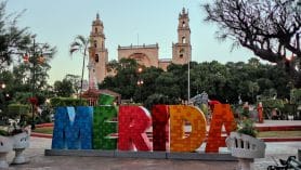 Blick auf den farbenfrohen Merida-Schriftzug mit Kathedrale Mérida Catedral de San Ildefonso im Hintergrund im mexikanischen Bundesstaat Yucatan.