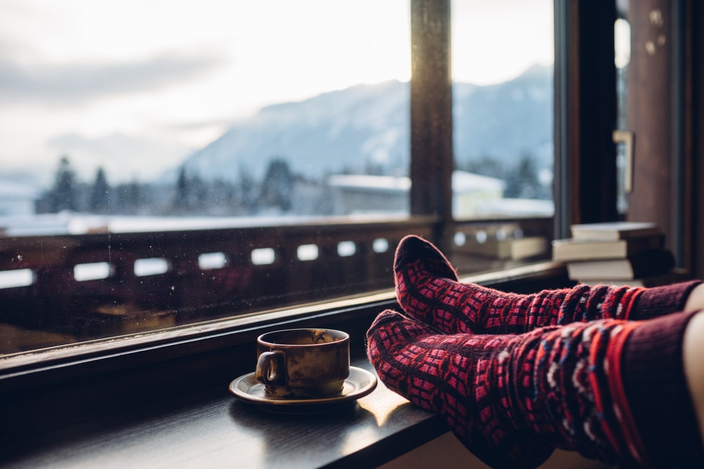 Warme Socken und Kaffee vor malerischer Bergkulisse