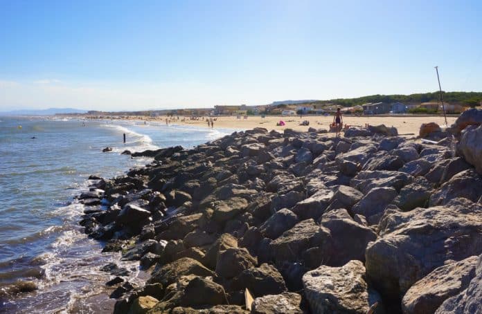 Dunkle Felsen am Sandstrand von Narbonne-Plage