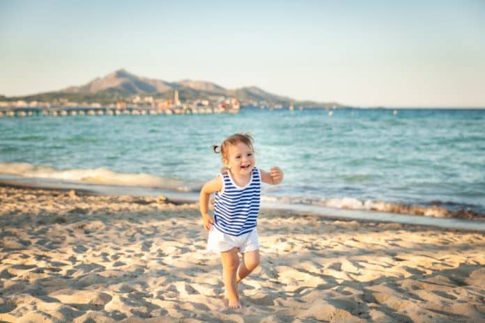 Kleines gut gelauntes Kind am Strand von Mallorca