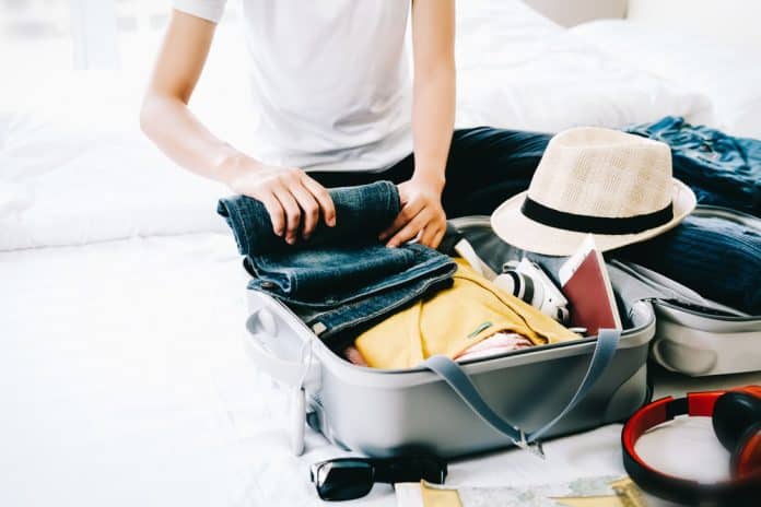 Woman,Packing,Travel,Bag,For,Summer,Vacation.,Tourism,And,Objects Frau packt ihren Uraubskoffer